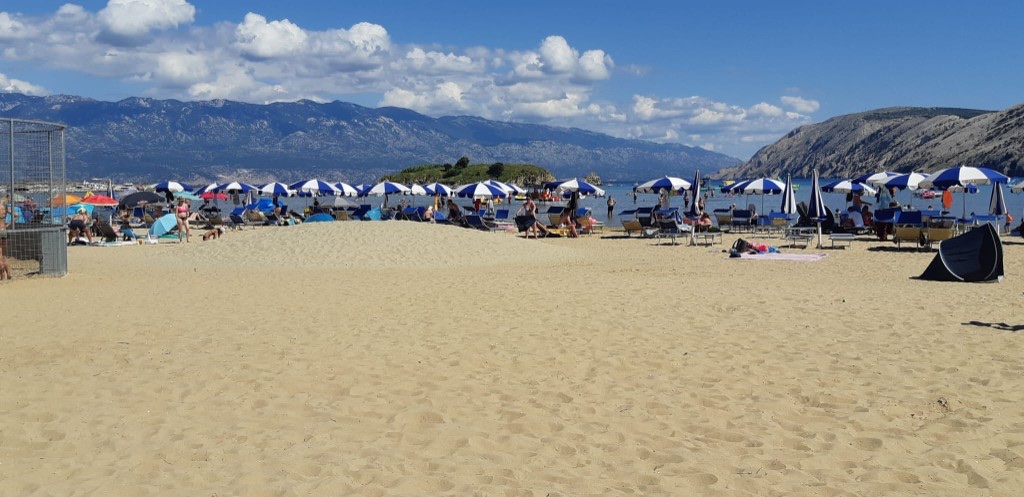 Rajska plaža in Lopar – Sandstrand mit Sonnenschirmen und türkisfarbenem Wasser